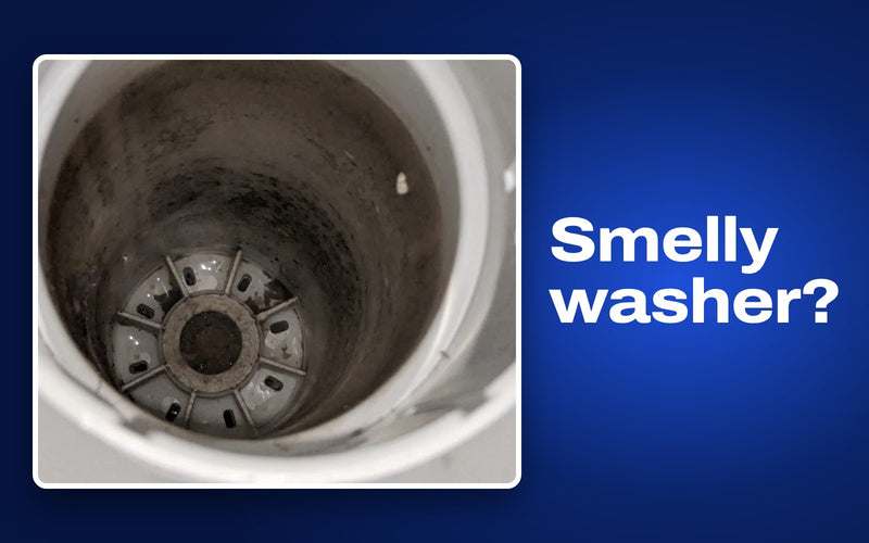 Real photo of black grime inside a top-load washer tub, where washer smells start