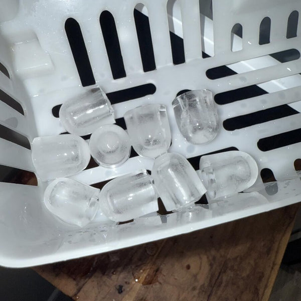Des glaçons clairs dans le panier d’une machine à glaçons de comptoir