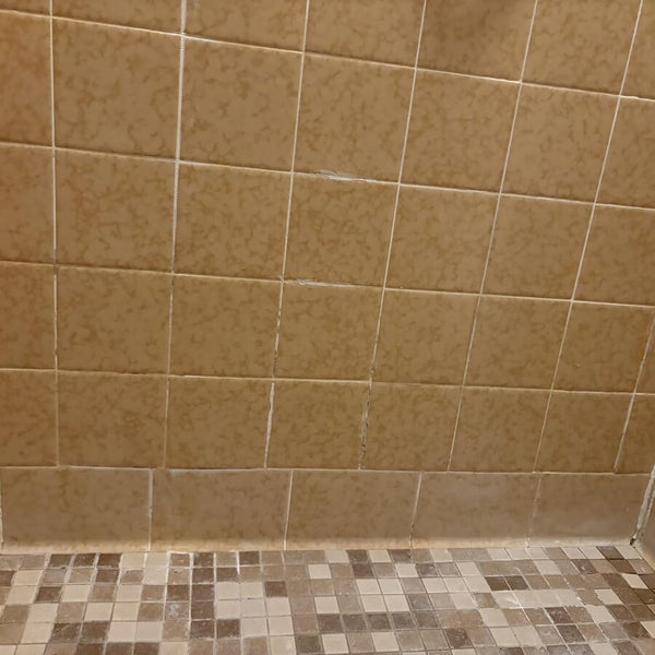Mur de douche en tuiles avec des lignes de coulis plus pâles après le gel