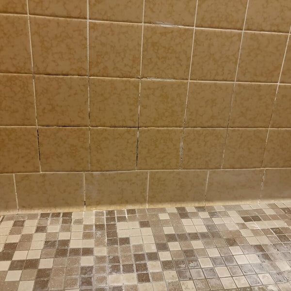 Mur de douche en tuiles avec des lignes de coulis foncées