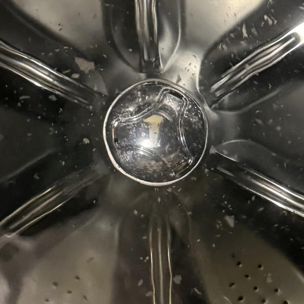Des particules de résidus au fond d’un tambour de laveuse